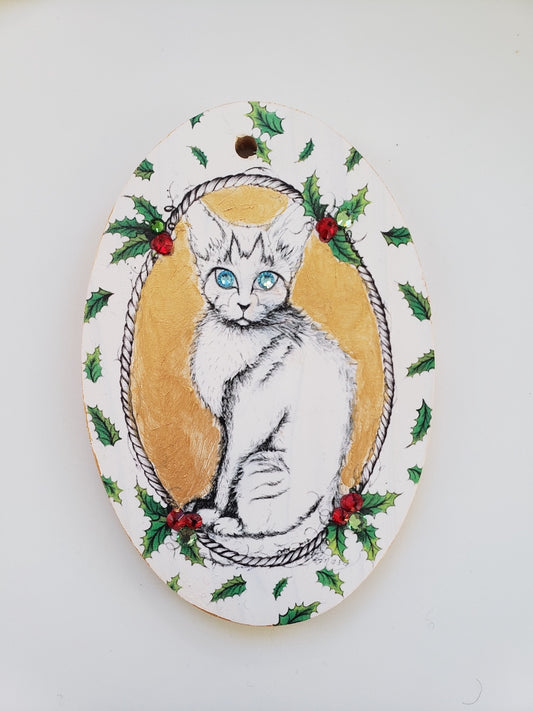 Decorative plaque with a cat illustration surrounded by holly leaves and berries on a white background