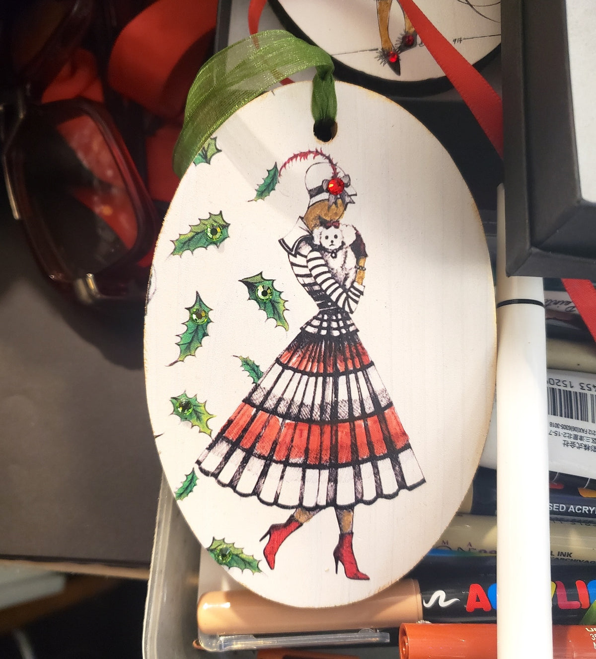 Hand painted wood ornament featuring MeowCleeva® in her signature red boots, adorned with Swarovski crystals. Holly border. One of a kind. $125.