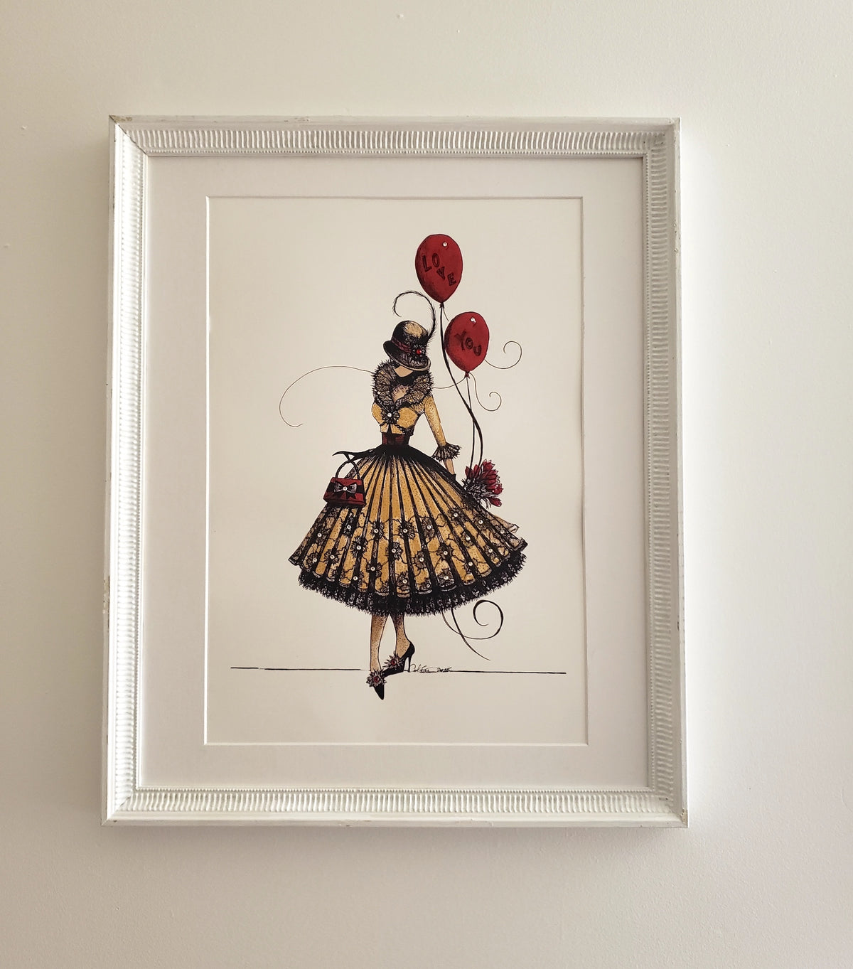 Framed art print featuring a vintage-style illustration of MeowCleeva in a black and gold dress with red balloons, displayed on a light beige wall. original art by artist Martha Colón