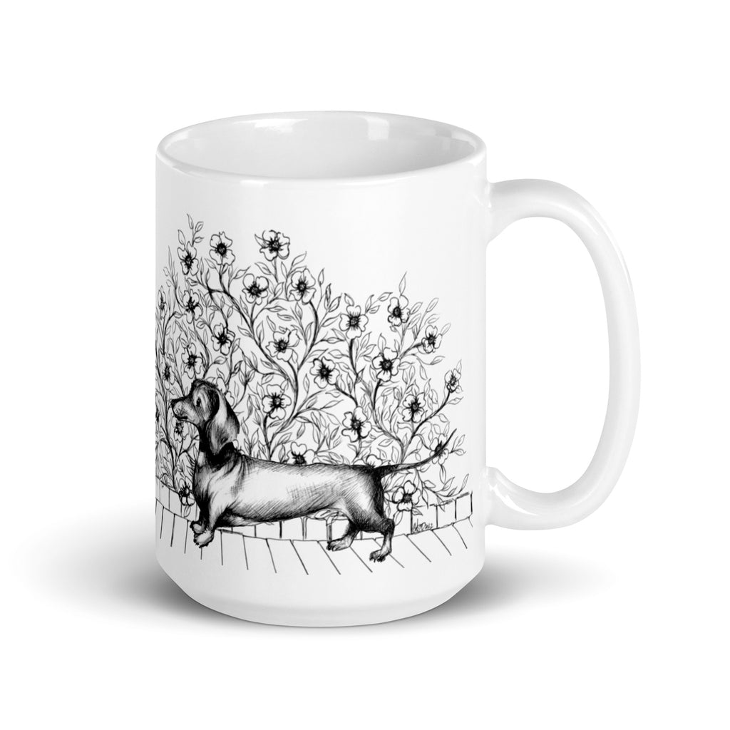 White mug with a black and white dachshund with ornamental floral design illustration by Martha Colón