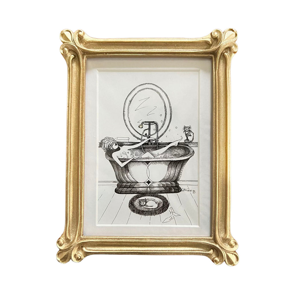 Framed artwork of a woman in a bathtub and two cats in the  room with a gold frame