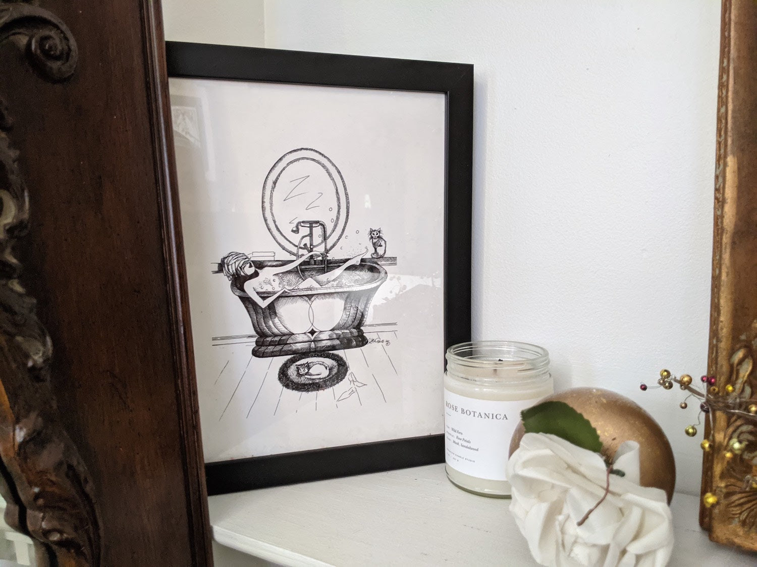 Framed black and white print of a vintage bathtub scene with cats on a shelf with decorative items.
